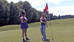 Beth and Georgia miming on a golf course