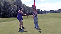 Beth and Georgia miming on a golf course